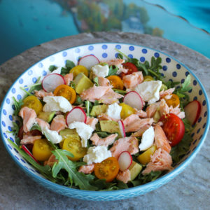 Arugula salad with salmon, goat cheese, avocado with a lemon vinaigrette